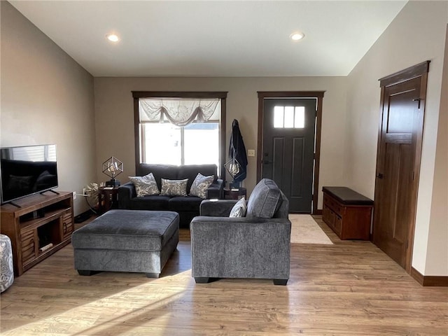 living area with recessed lighting, light wood-type flooring, baseboards, and vaulted ceiling