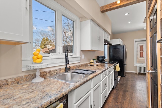 kitchen featuring stainless steel electric stove, radiator heating unit, a sink, under cabinet range hood, and white cabinetry