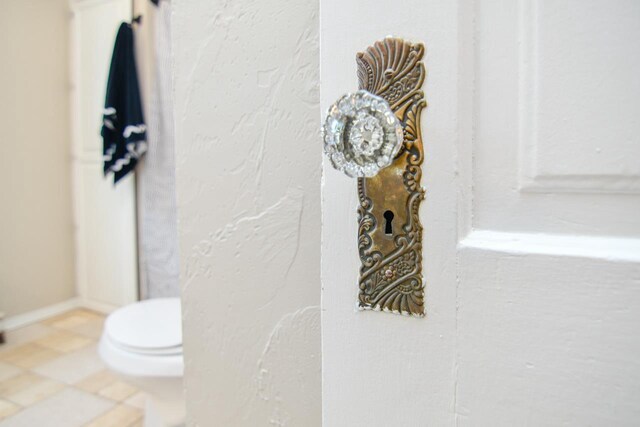 bathroom with toilet and baseboards