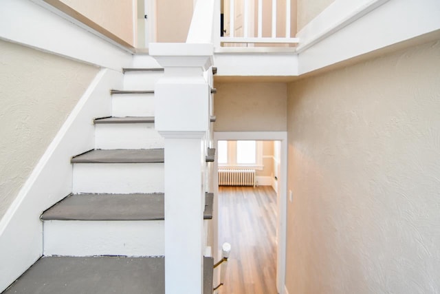 stairs with a high ceiling and radiator heating unit