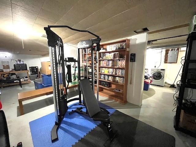 workout room with washer and clothes dryer and electric panel