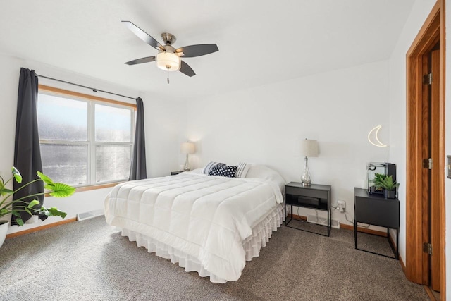 bedroom featuring visible vents, baseboards, dark colored carpet, and ceiling fan