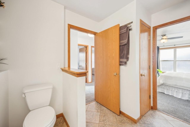 ensuite bathroom with toilet, a ceiling fan, baseboards, and ensuite bathroom