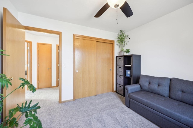 living area featuring carpet flooring and ceiling fan