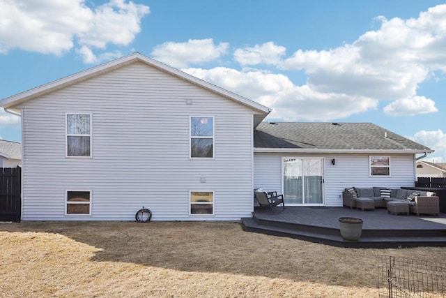 rear view of house featuring a lawn, a deck, an outdoor living space, fence, and roof with shingles