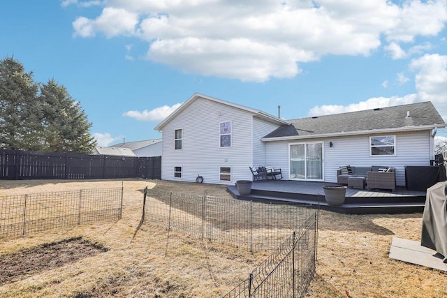 back of property with a wooden deck, a yard, a fenced backyard, and a shingled roof