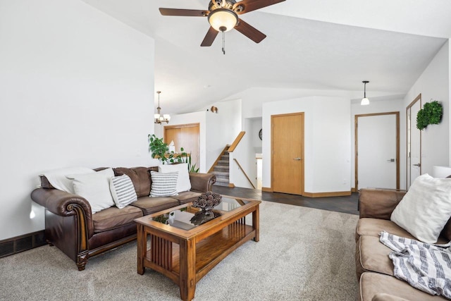 living area featuring visible vents, stairway, carpet floors, vaulted ceiling, and ceiling fan with notable chandelier