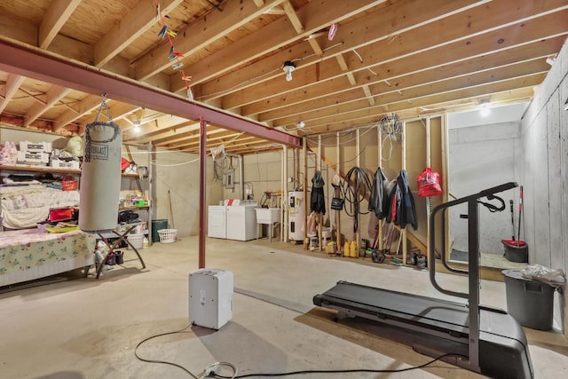 unfinished basement featuring washer and dryer and electric water heater