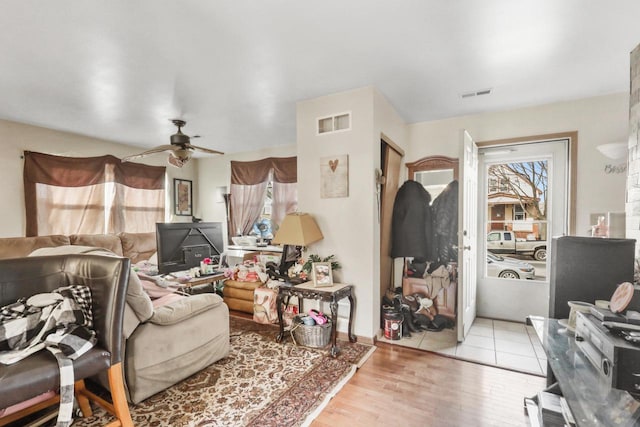 living area with visible vents, ceiling fan, and wood finished floors