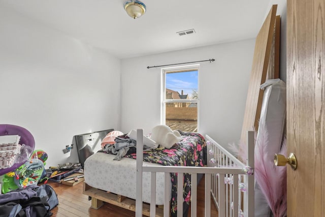 bedroom featuring visible vents and hardwood / wood-style floors