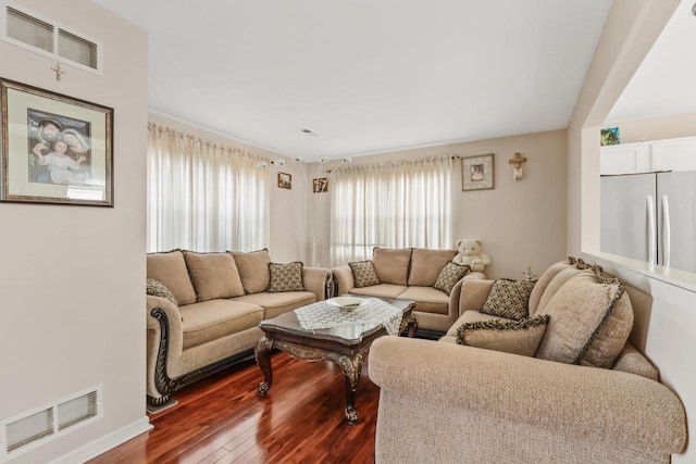 living area featuring visible vents and dark wood-style floors