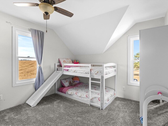 carpeted bedroom featuring multiple windows, ceiling fan, and vaulted ceiling