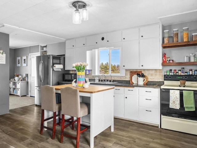 kitchen with wood counters, dark wood-type flooring, white cabinets, and electric stove