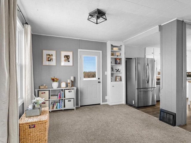 kitchen with carpet, visible vents, and freestanding refrigerator