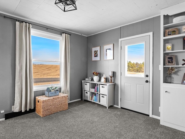 doorway to outside with a wealth of natural light, baseboards, carpet flooring, and crown molding