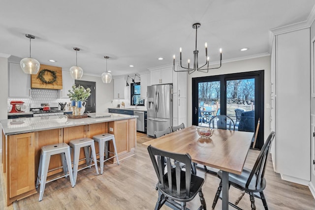 dining area with recessed lighting, light wood-style flooring, and crown molding