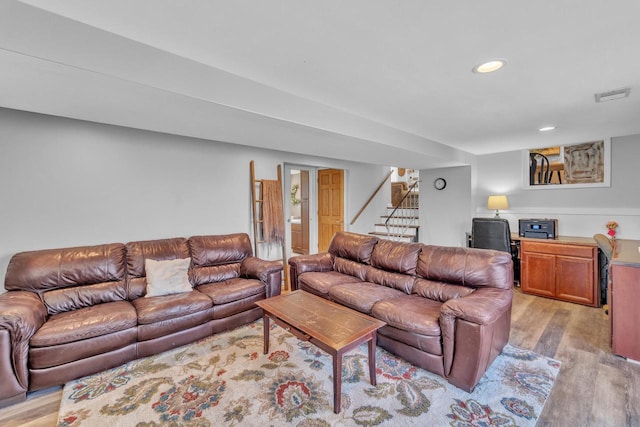 living room featuring stairs, light wood-style flooring, recessed lighting, and visible vents