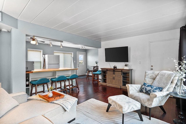 living area with wood finished floors and a ceiling fan