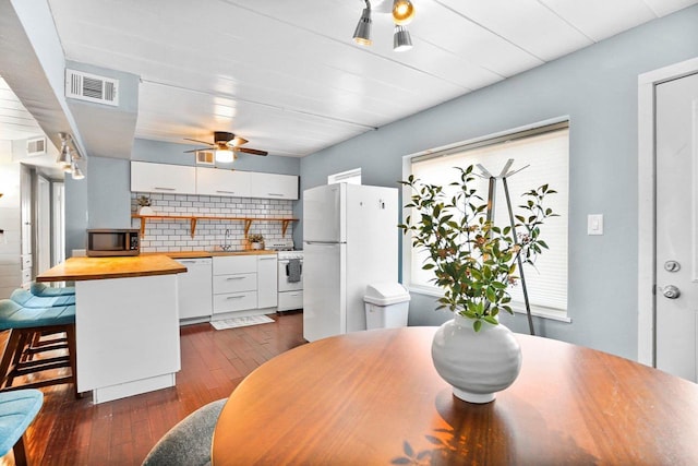 dining area with dark wood finished floors, visible vents, and ceiling fan