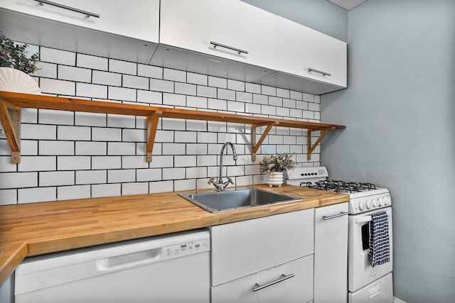 kitchen featuring wooden counters, decorative backsplash, white appliances, white cabinetry, and a sink