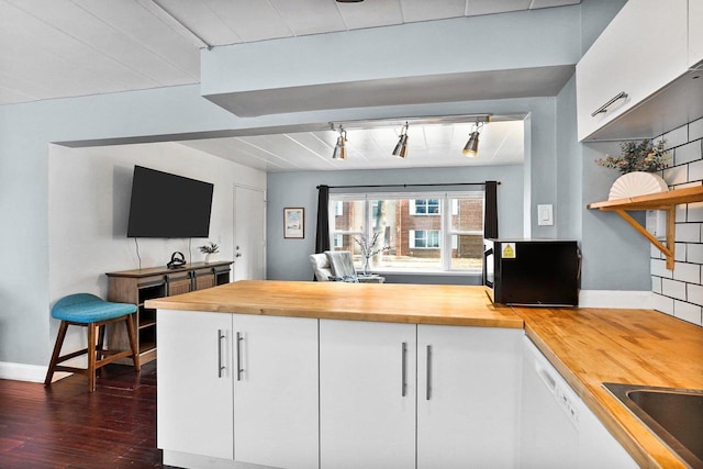 kitchen with baseboards, rail lighting, white cabinets, wood counters, and dark wood-style flooring