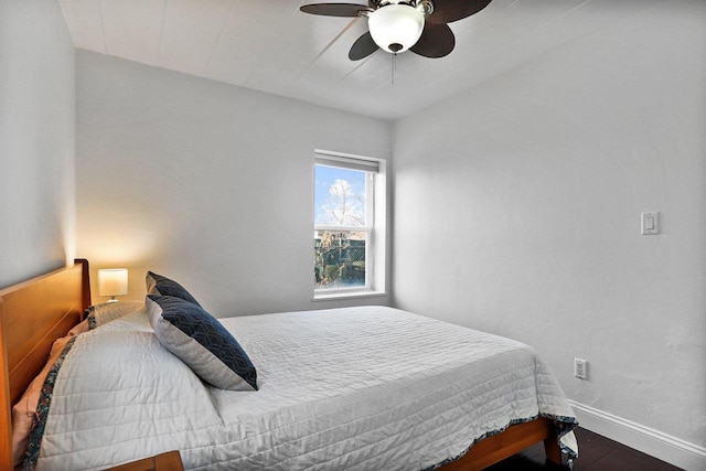 bedroom featuring ceiling fan, baseboards, and wood finished floors