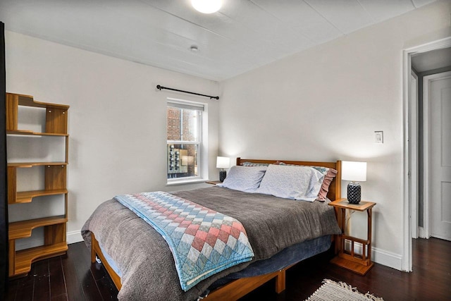 bedroom with baseboards and wood finished floors