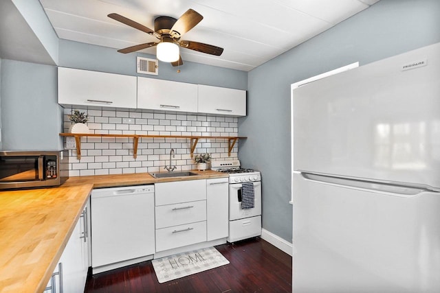 kitchen with visible vents, a sink, white cabinetry, white appliances, and butcher block counters