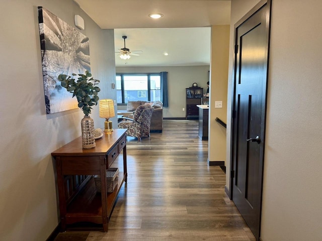 corridor with recessed lighting, baseboards, and wood finished floors