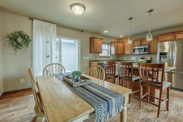 dining room with recessed lighting, baseboards, and light wood-style flooring