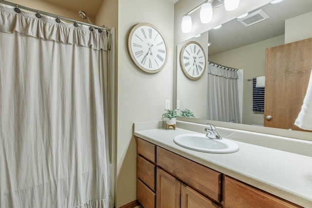 bathroom featuring a shower with shower curtain, visible vents, and vanity