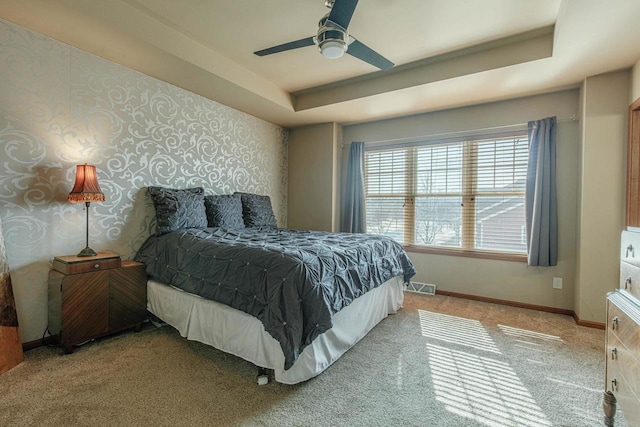 bedroom featuring wallpapered walls, baseboards, and a tray ceiling