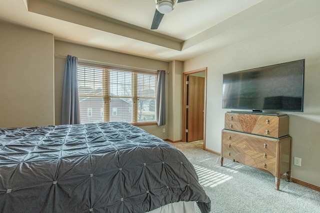 bedroom featuring a ceiling fan, a raised ceiling, carpet, and baseboards