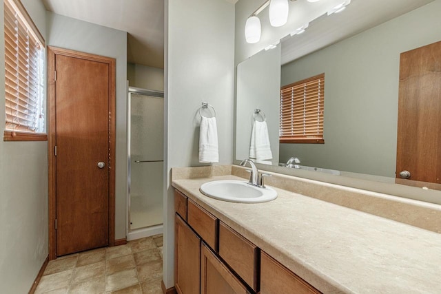 full bath with baseboards, a stall shower, and vanity