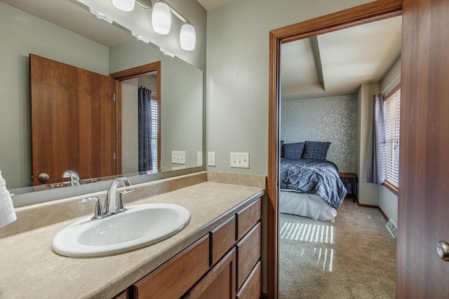 ensuite bathroom with visible vents, vanity, ensuite bathroom, and baseboards