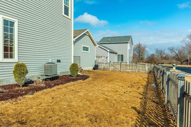 view of yard with central air condition unit and fence