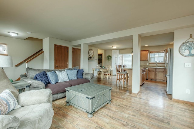 living room featuring light wood-type flooring and stairs