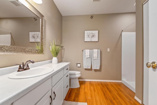 full bath featuring visible vents, toilet, wood finished floors, baseboards, and vanity