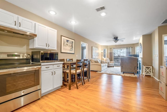 kitchen featuring visible vents, under cabinet range hood, stainless steel appliances, white cabinets, and light wood finished floors