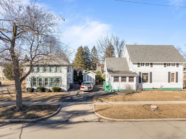 colonial home featuring a shingled roof