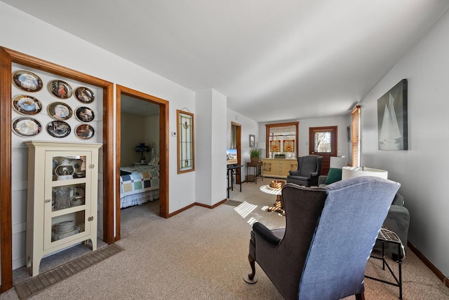 living area featuring light colored carpet and baseboards