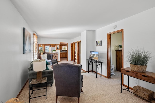 living area with light colored carpet and baseboards