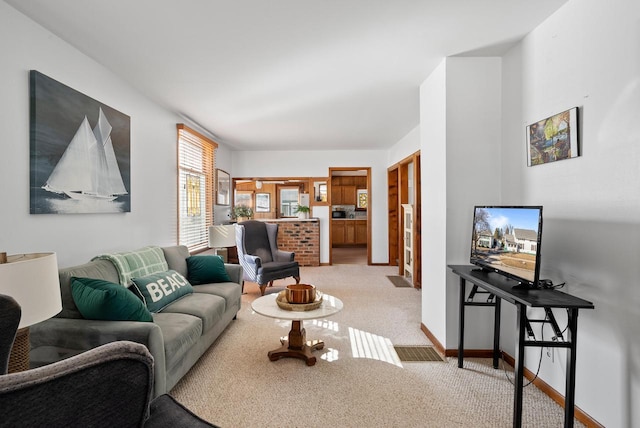 living area with light colored carpet and baseboards