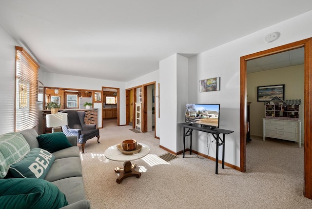 living area featuring light colored carpet and baseboards