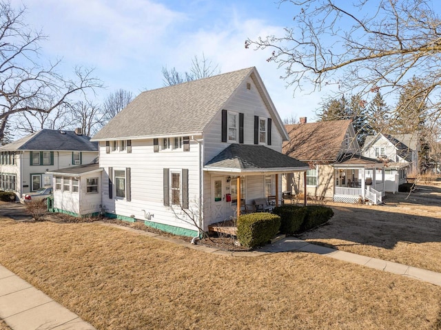 view of front facade with covered porch, a front lawn, and a shingled roof