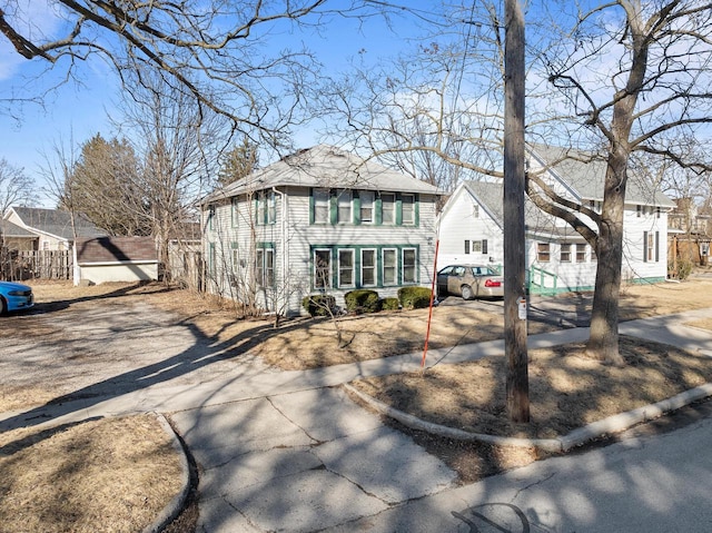 view of front of house featuring fence, a residential view, and driveway