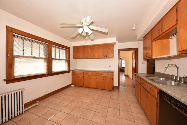 kitchen featuring a ceiling fan, radiator heating unit, a sink, black dishwasher, and brown cabinets