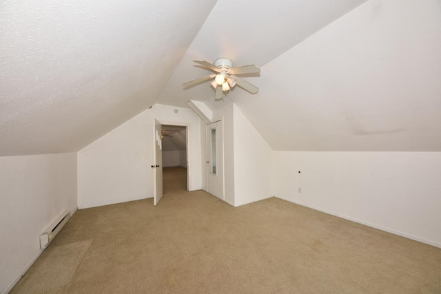 additional living space featuring light colored carpet, lofted ceiling, baseboard heating, a textured ceiling, and a ceiling fan