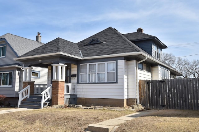 bungalow with a shingled roof, fence, covered porch, and a chimney