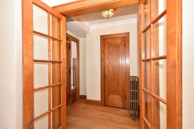 corridor featuring ornamental molding, baseboards, and wood finished floors